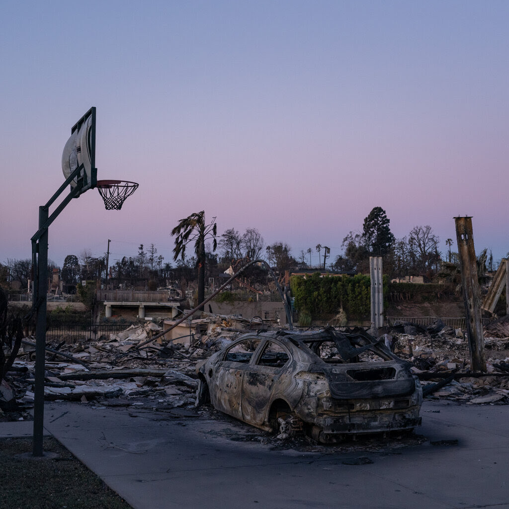 A basketball hoop and a completely burned car are among the remains left behind by a fire in a residential area.