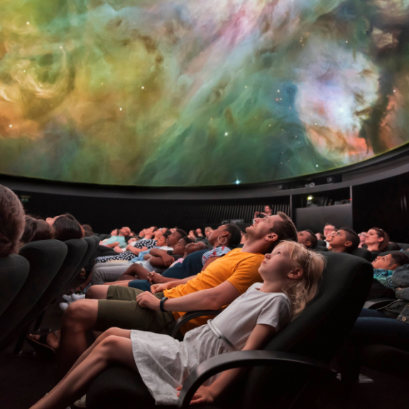 Children and adults sat in the Planetarium's chairs watchin the show