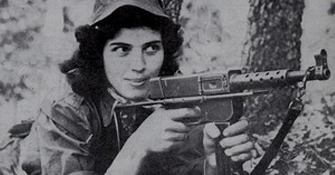 A female fighter of the FLN posing with her gun during the Algerian War of Independence against the French.