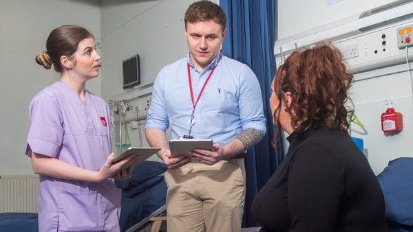 A doctor and nurse consult with a pregnant patient.