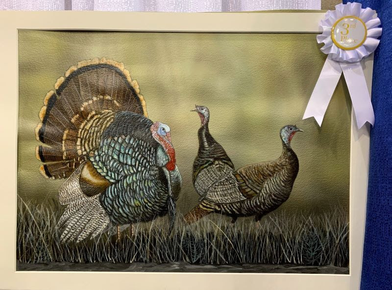 Painting with white ribbon of three turkeys in brown grass