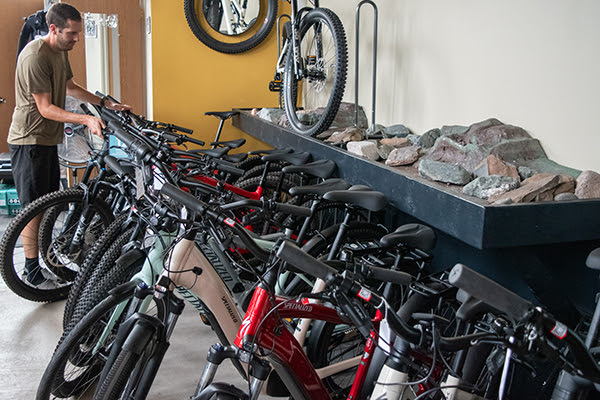 Jacob Douglas, co-owner of Lakeshore Bike in Marquette, looks over a selection of Class-1 and Class-3 e-bikes.