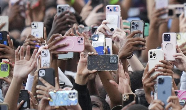 Supporters of Vice President Kamala Harris hold up their phones as she delivers a concession speech for the 2024 presidential election, Wednesday, Nov. 6, 2024, on the campus of Howard University in Washington. (AP Photo/Stephanie Scarbrough)