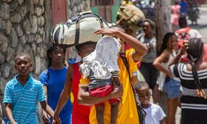 Desplazadas por la escalada de violencia, las familias de Haití cargan con sus pertenencias mientras huyen de sus hogares en busca de seguridad.