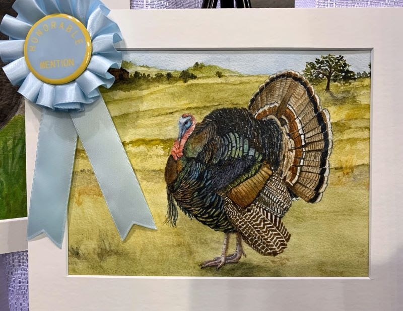 Painting with light blue ribbon of a turkey in yellow grassland