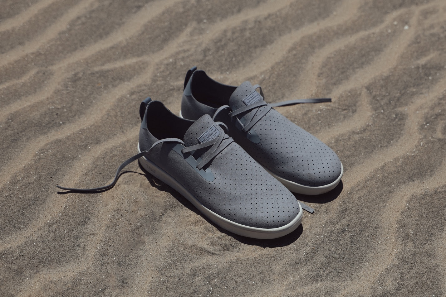 A pair of grey shoes on sandAI-generated content may be incorrect.