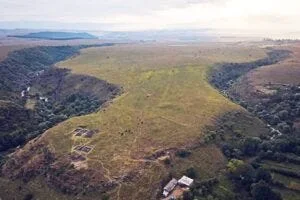 Atmospheric photo of the site at dusk, showing the location at the convergence of two gorges. 2023 excavations of inner fortress are visible in foreground.