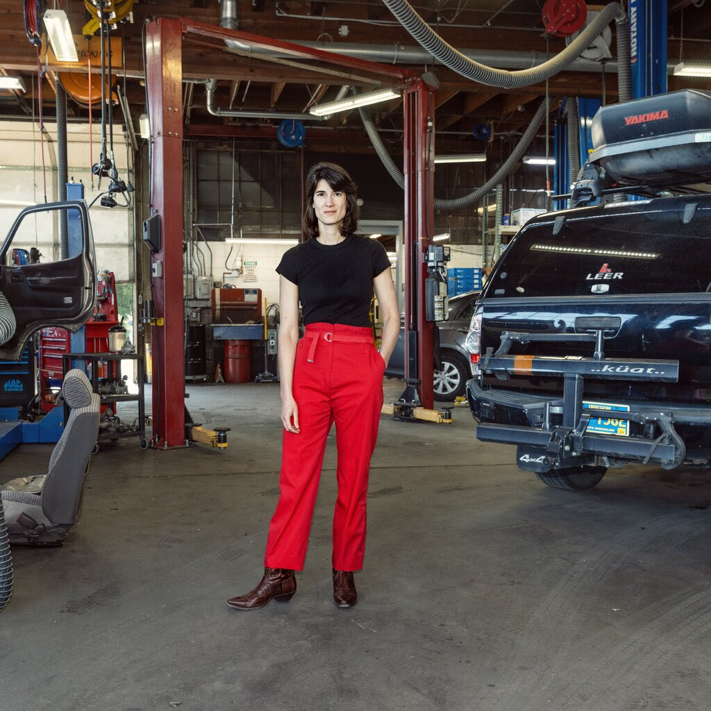 Marie Gluesenkamp Perez standing in an auto body shop.