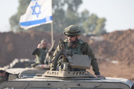 Israeli soldiers sit on their vehicles close to the Gaza border in southern Israel