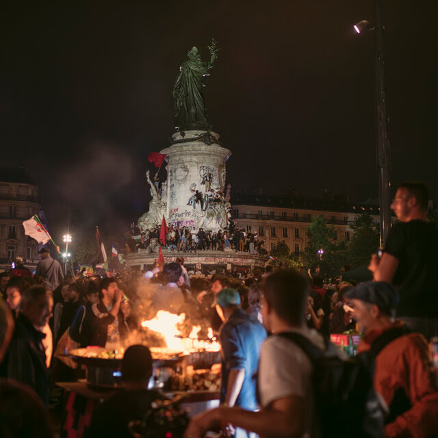 A crowd of people at a monument at night.