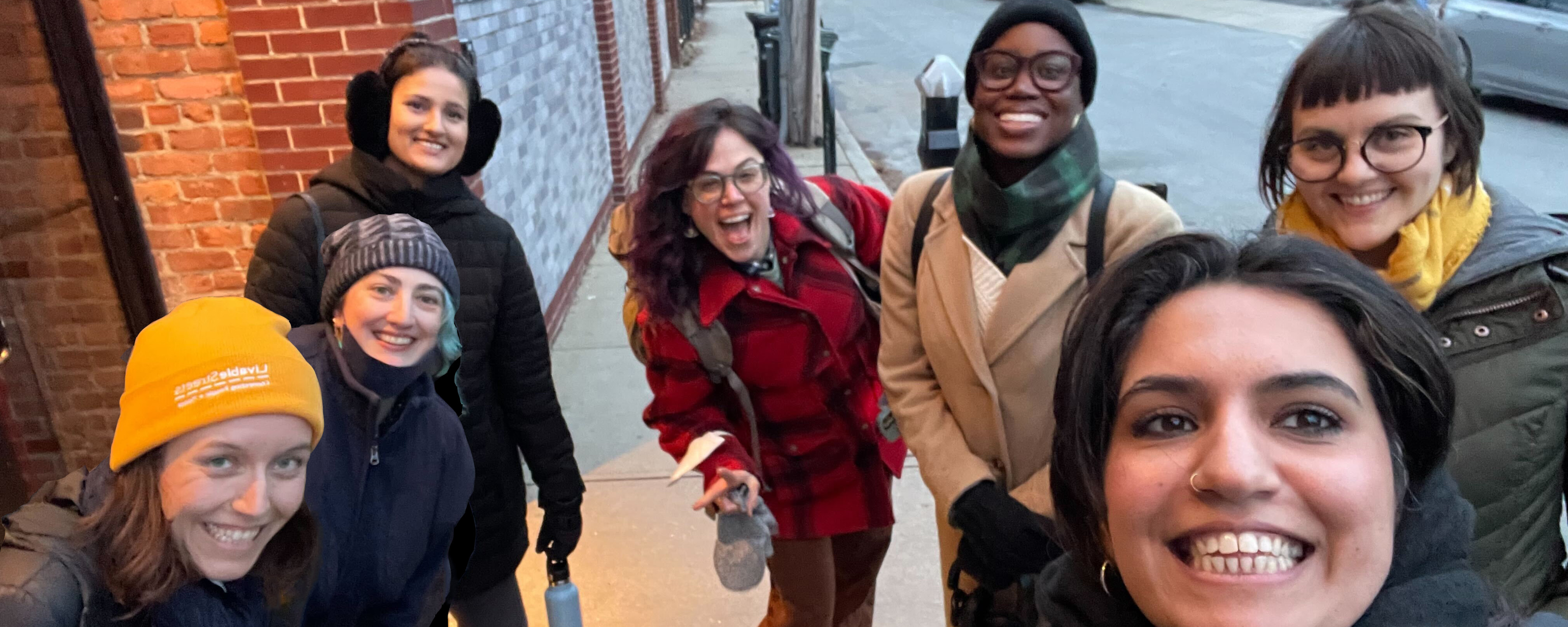 the livablestreets team outside flatbread pizza in davis sqare. clockwise from bottom left: michaela, lorraine, ammi, abby, makayla, stacy, with maha in foreground taking the selfie