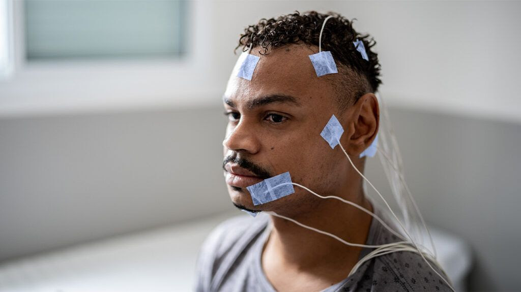 A man with electrodes taped to his head for brain stimulation therapy-2