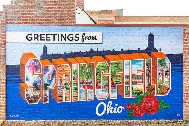 The Greetings from Springfield, Ohio, mural has become a landmark of downtown. United Methodists in Ohio and beyond are stepping up to extend a similar welcome and show support for Haitian immigrants in the city. Springfield experienced more than 30 bomb threats after being targeted by anti-immigrant rhetoric based on false claims. Photo courtesy of Greetings Tour; used with permission.