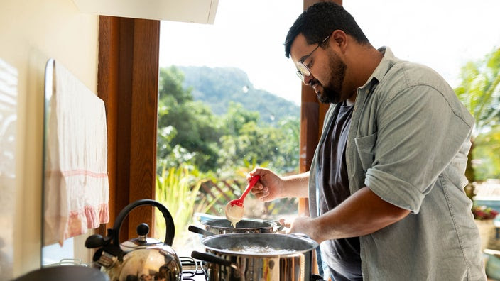 Man cooking food on his kitchen stove at home.