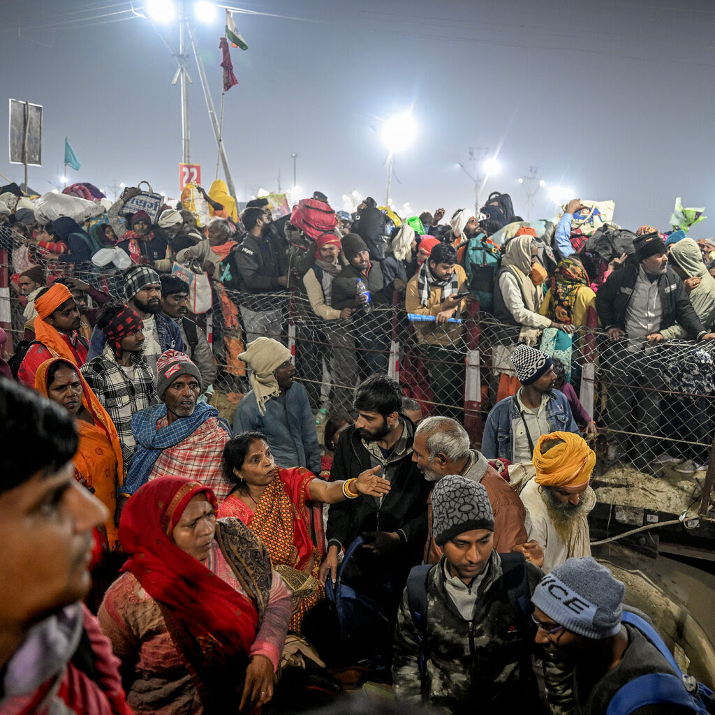 A large crowd pressed along a short fence on a bridge.