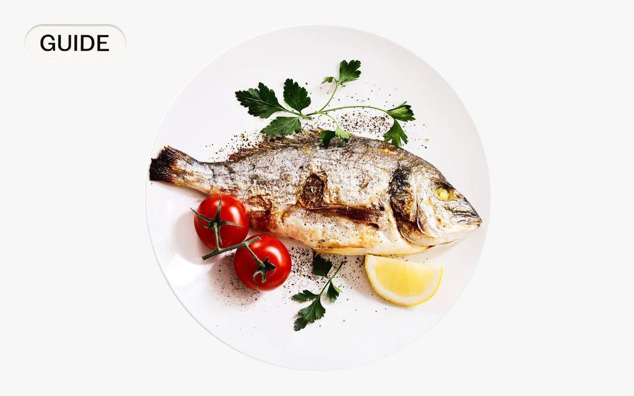 Fish plated with lemon, tomatoes and parsley