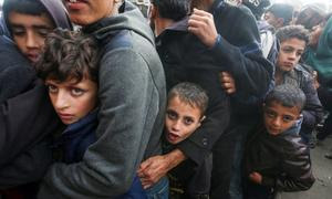 Gente haciendo colar para recibir pan en Khan Younis, Gaza.