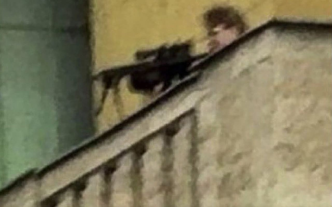 Grainy photographs quickly began to circulate online, showing a man in black clothing wielding an assault rifle on the roof walkway of the university building