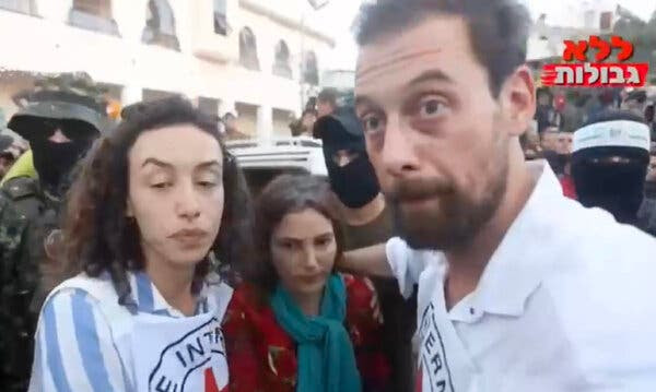 A woman newly freed by her captors between two Red Cross workers