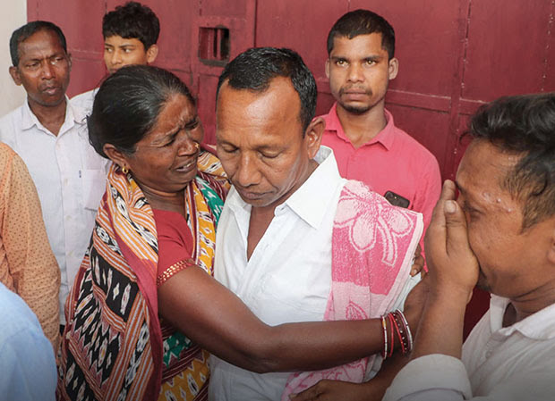 Man embraced by a woman who is crying