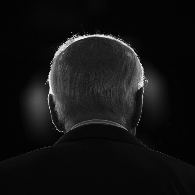 A black and white photograph of the back of Joe Biden’s head.