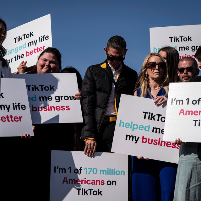 A crowd of people, all holding signs that support TikTok.