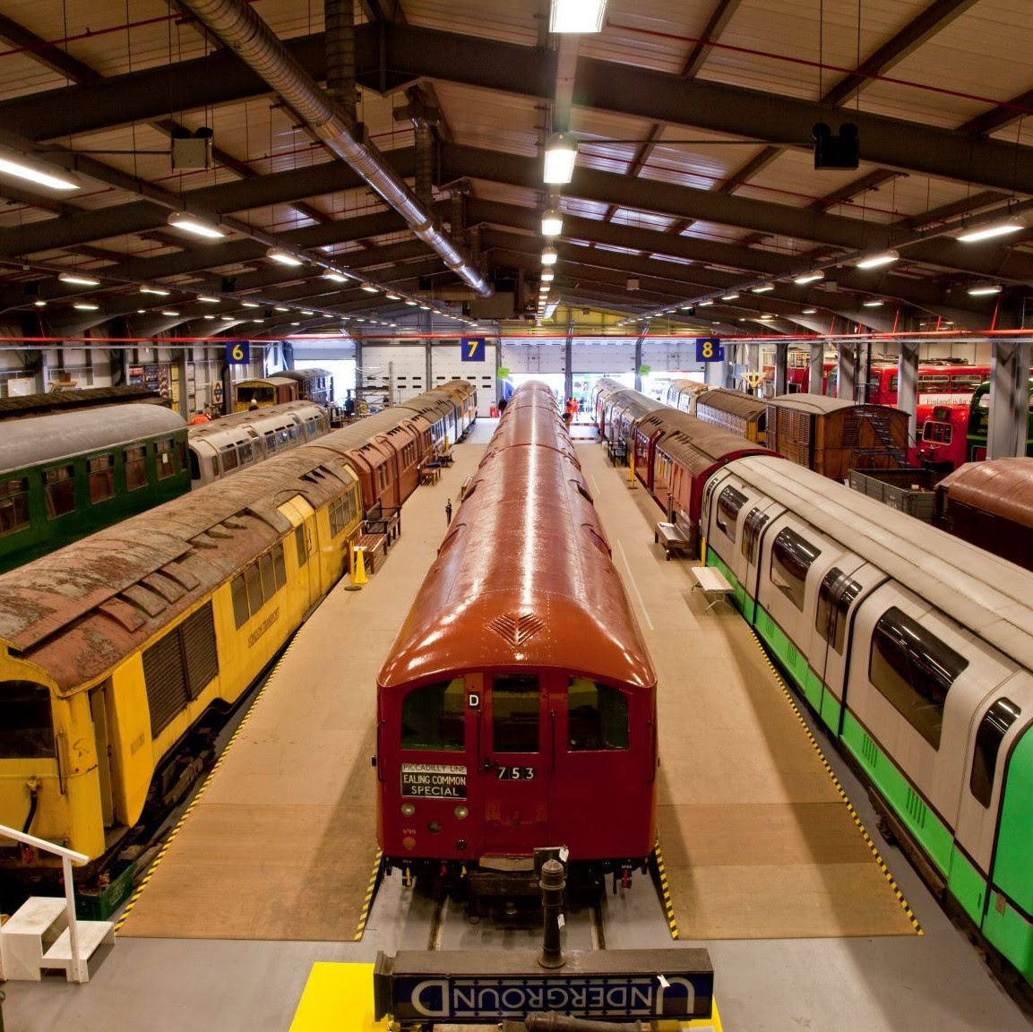 Elevated view looking down onto brightly coloured heritage trains stationed at Acton Depot