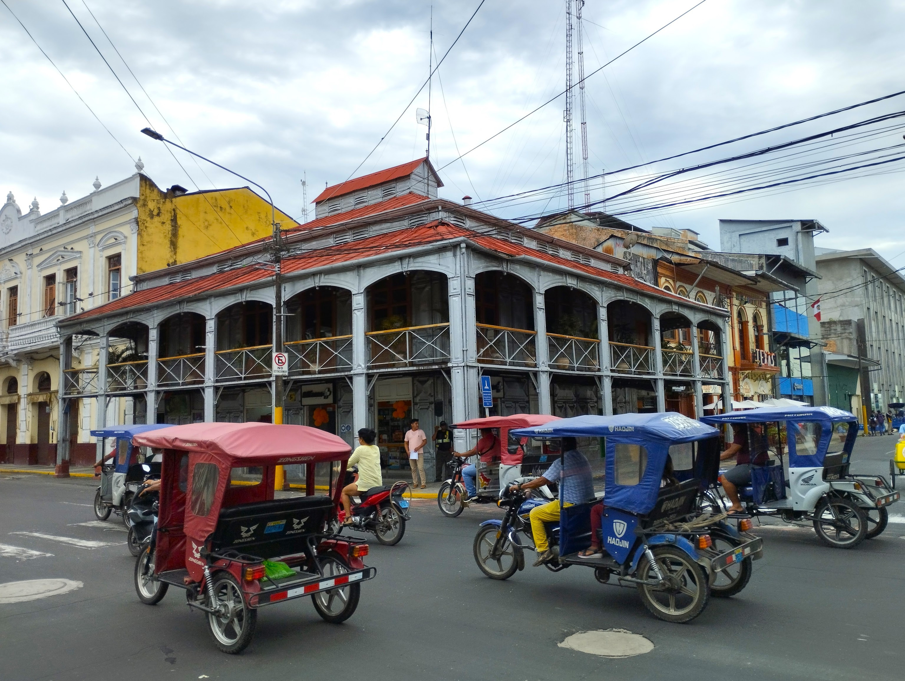 Los motocarros pasan ante la Casa de Fierro, en Iquitos.