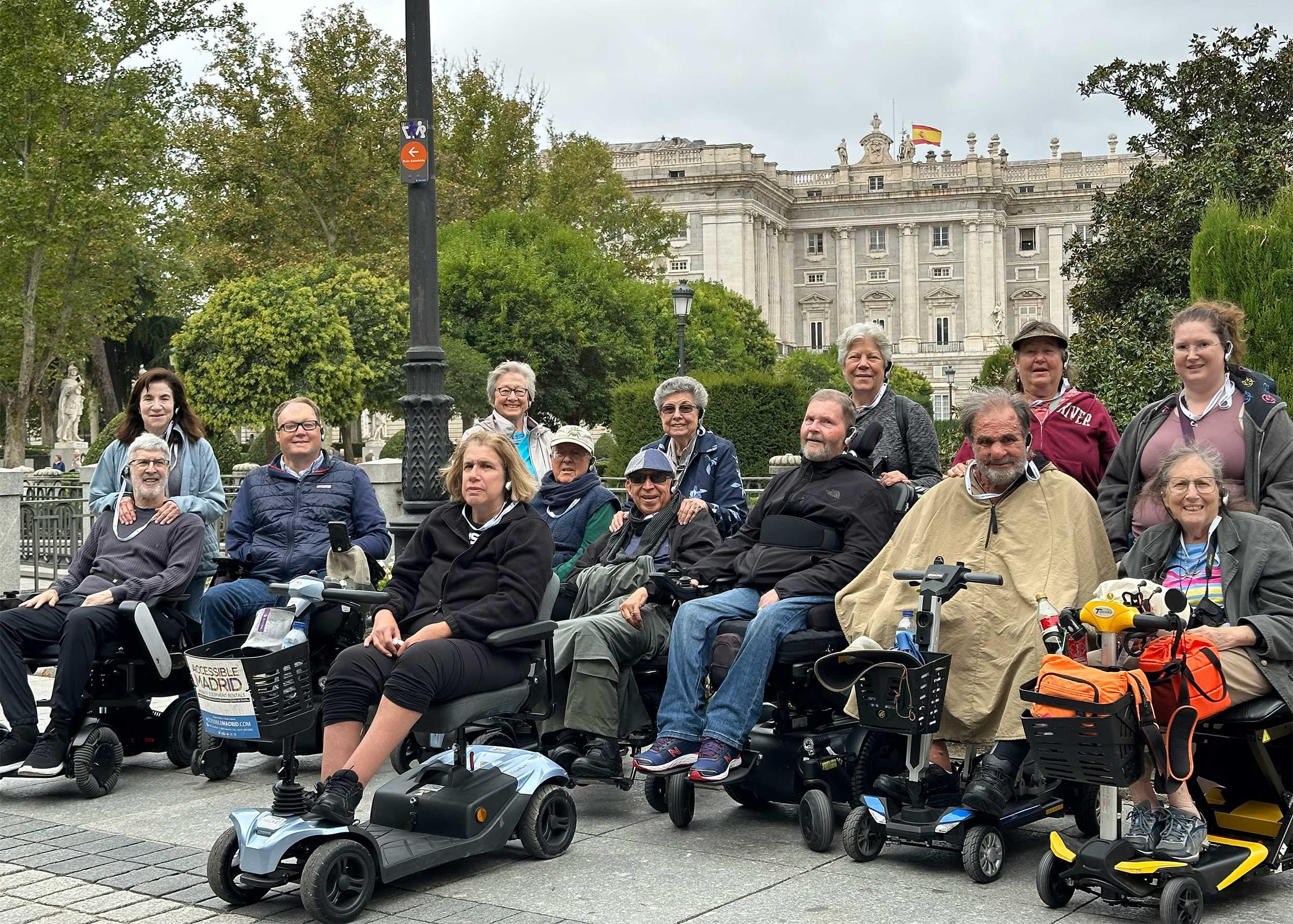 Group of wheelchair users and companions in front of royal palace.