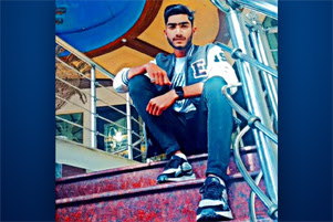 Farhan is sitting on some steps.