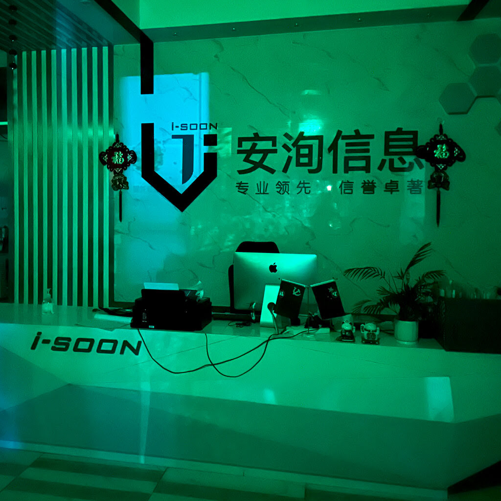 An office’s reception desk with a computer on the top and a label of “I-Soon” on the front, in front of a company logo.