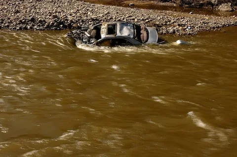 Destroyed car at the Biala Ladecka river lies submerged after flooding in Zelazno, Poland,