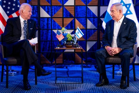 two men in suits sit across from each other