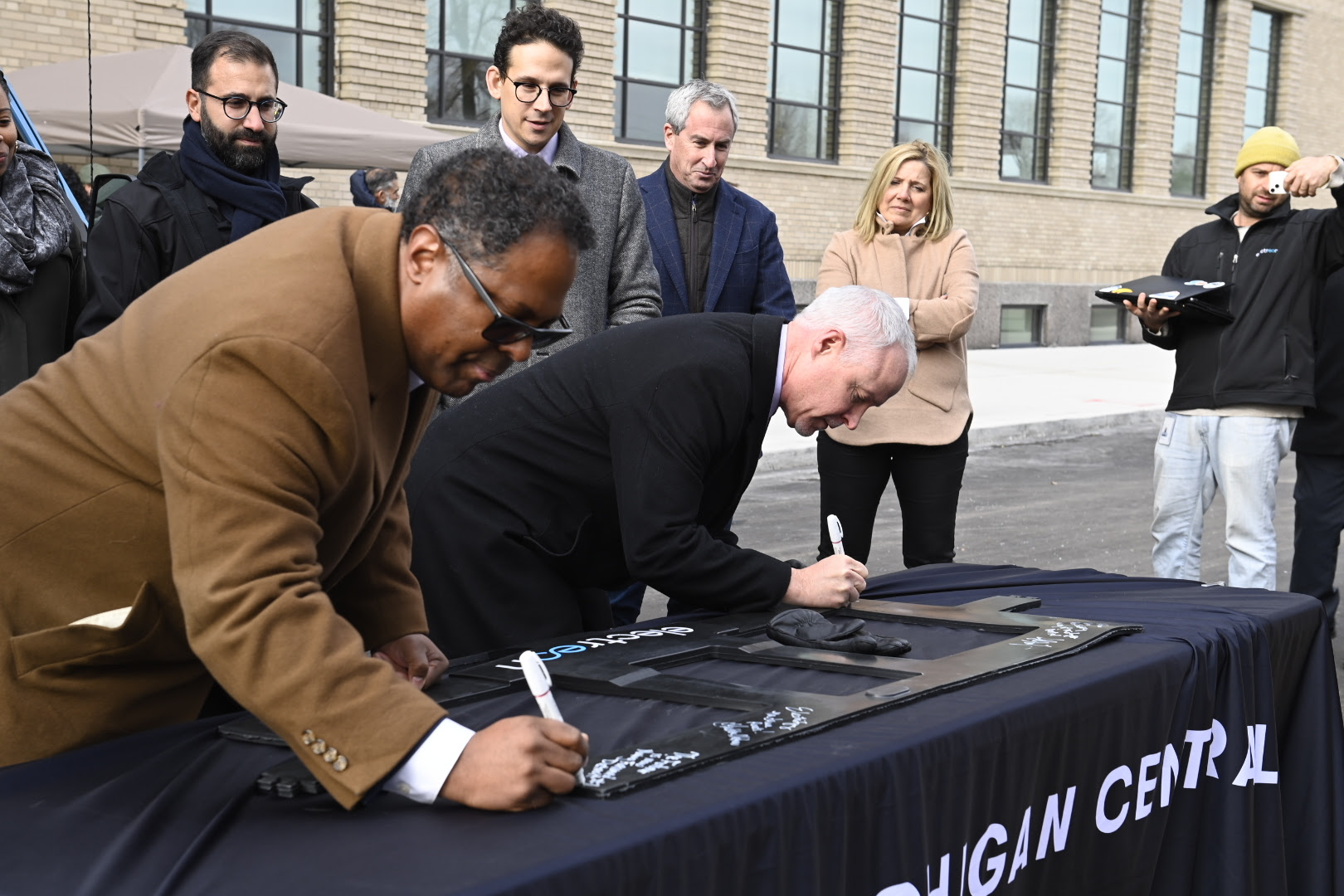 MDOT Director Bradley C. Wieferich and Detroit Deputy Mayor Todd Bettison sign an Electreon coil.