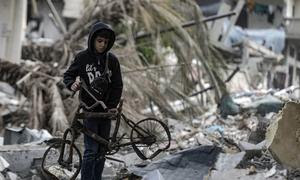 Un niño recupera una bicicleta rota en la zona de Al-Touam, en el norte de la Franja de Gaza.