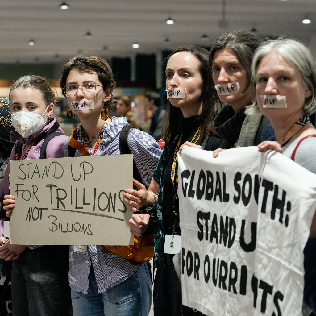 A demonstration at the COP29 summit in support of climate financing for developing countries. One sign reads, “Stand up for trillions, not billions.”