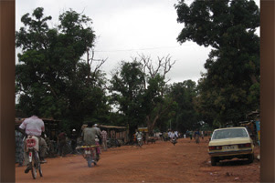 A dirt street in what appears to be a village.