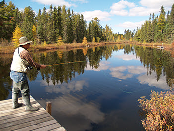 A fly fisherman enjoys a beautiful day on an inland waterway in the Upper Peninsula. (Photo courtesy of John Pepin) 