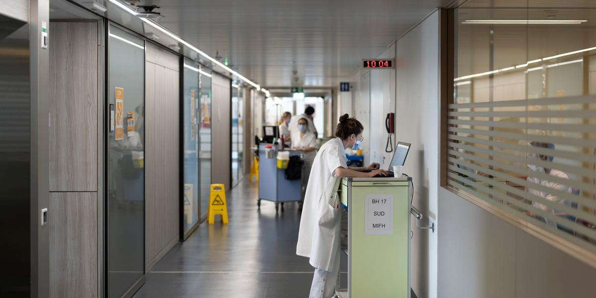 Une femme medecin consulte le dossier d un patient sur son ordinateur avant d entrer dans la chambre pour la visite du matin dans le service de medecine interne du Centre hospitalier universitaire vaudois (CHUV),le mardi 23 aout 2022 a Lausanne. (KEYSTONE/Gaetan Bally)