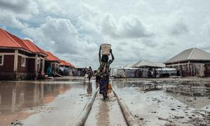 Millones de personas siguen desplazadas en Nigeria debido a los conflictos, los efectos del cambio climático y las catástrofes naturales. En esta foto de archivo, una niña lleva agua a su refugio en un campo de desplazados internos en el noreste del país.