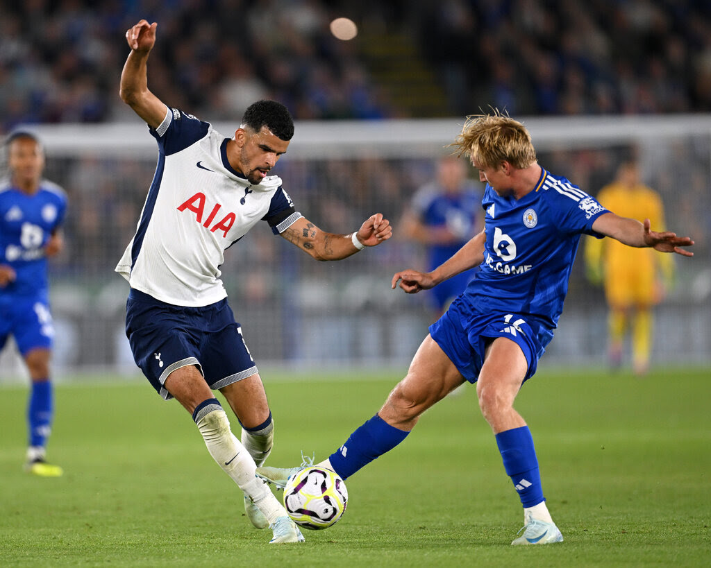 Two soccer players fight for control of the ball.