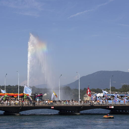 epa11489510 Ravers dance on and around Love Mobiles as they walk on Mont-Blanc Bridge during the 22nd edition of the Lake Parade in Geneva, Switzerland, 20 July 2024. EPA/SALVATORE DI NOLFI