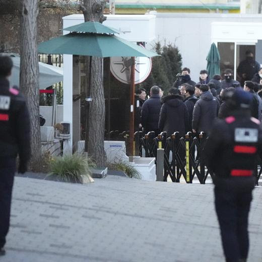 Investigators from the Corruption Investigation Office for High-ranking Officials arrive at the gate of the presidential residence as supporters of impeached South Korean President Yoon Suk Yeol stage a rally to oppose a court having issued a warrant to detain Yoon, in Seoul, South Korea, Friday, Jan. 3, 2025. (AP Photo/Lee Jin-man)