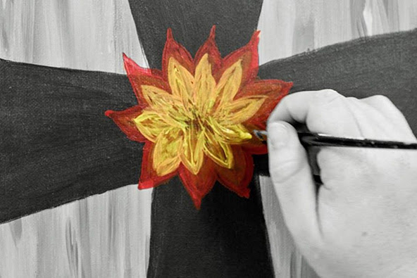Artist painting flower on cross