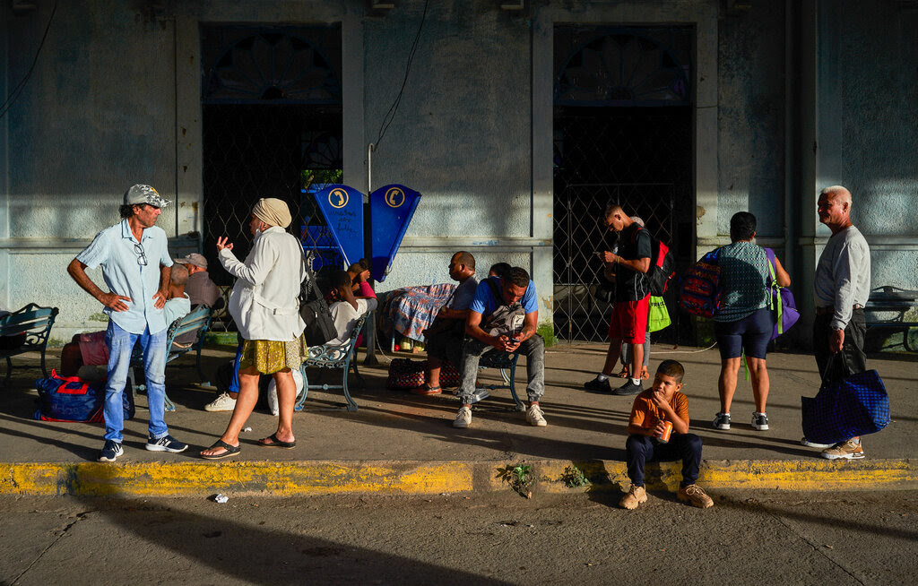 A group of people on the sidewalk waiting and talking to each other in Matanzas, Cuba.