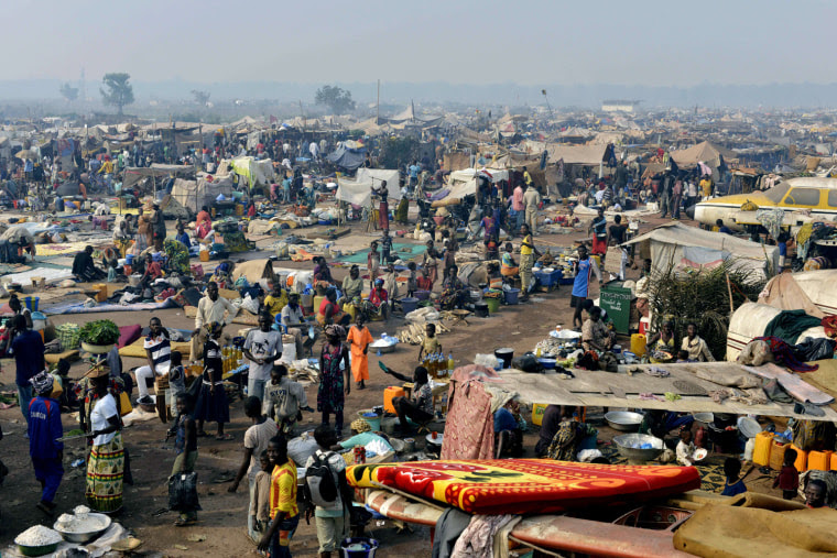 People gather at camp for internally displaced persons set up amid old aircrafts near the airport in Bangui on Dec. 29, 2013.