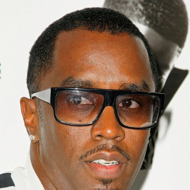 Sean Combs wears slightly tinted sunglasses and looks past the camera.