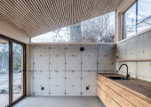 La cocina y el comedor se abren hacia el jardín mediante puertas correderas de vidrio que bañan el espacio de luz.