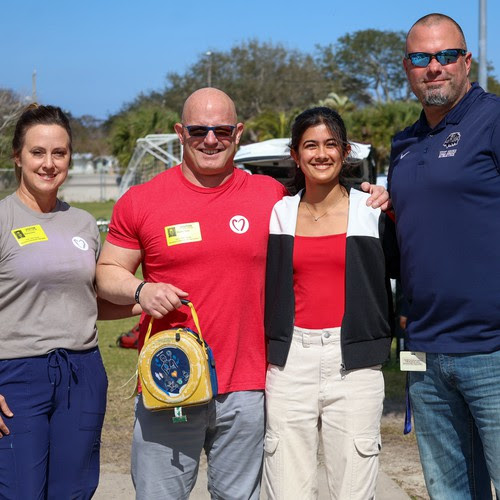 a photo of Rhea, Principal Clarke, and members of Who We Play For