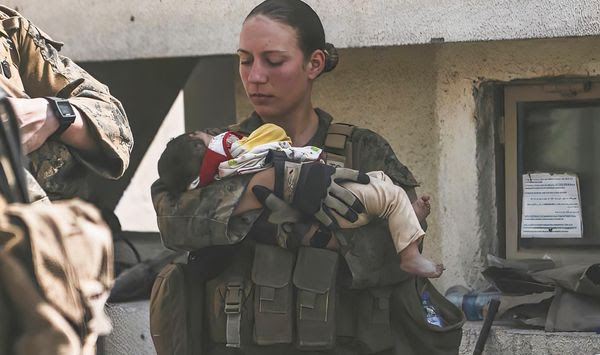 In this Aug. 20, 2021, image provided by the U.S. Marine Corps, Marines assigned to the 24th Marine Expeditionary Unit (MEU), including Sgt. Nicole Gee calms an infant during an evacuation at Hamid Karzai International Airport in Kabul, Afghanistan. Officials said Aug. 28, that Gee of Sacramento, Calif., was one of the Marines killed in Thursday&#x27;s bombing at the airport. (Sgt. Isaiah Campbell/U.S. Marine Corps via AP)